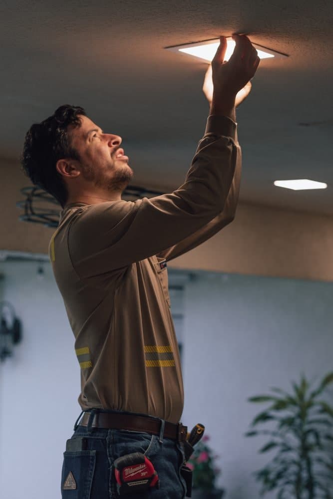 Josiah Hirsh pressing a slim recessed light up into a ceiling